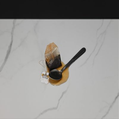 Fake Tea Bag and Spoon in a Puddle of Tea