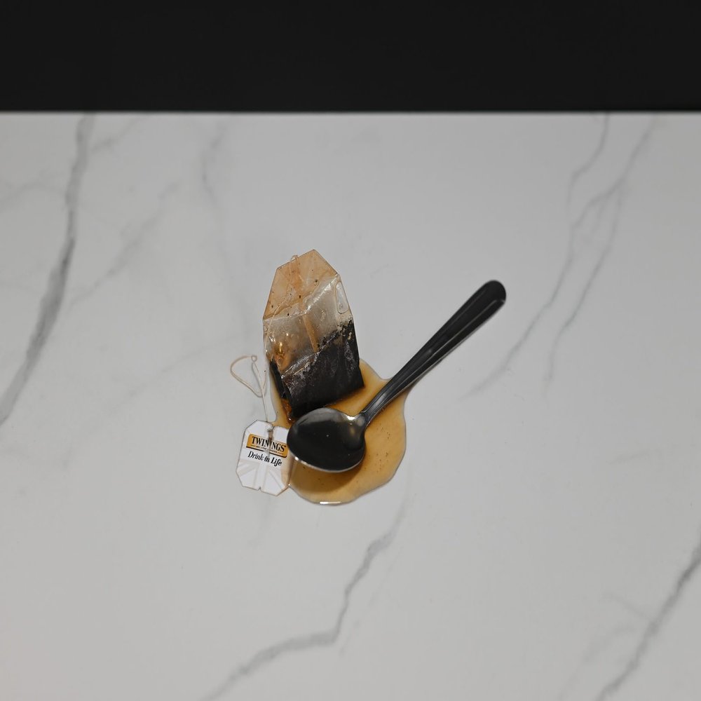 Fake Tea Bag and Spoon in a Puddle of Tea